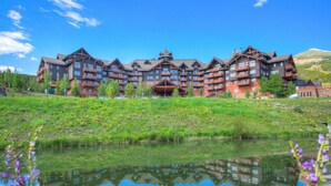 A large, multi-story hotel with a central courtyard and a reflective pond. - Luxury 4 Bedroom Condo on Peak 8 4 Condo (Breckenridge)
