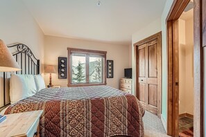 Relax in a serene bedroom with a large bed, a wardrobe, and a desk, offering a peaceful retreat.