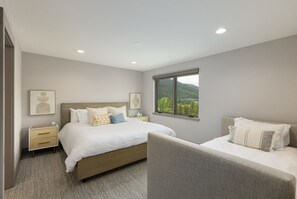 Relax in a serene space with a large bed, bedside tables, and a window offering a view of the outdoors.