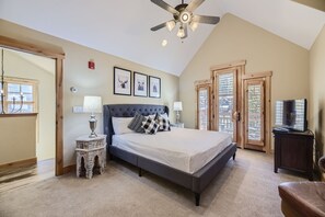 Cozy retreat with a large bed, ceiling fan, and TV, offering a peaceful atmosphere.