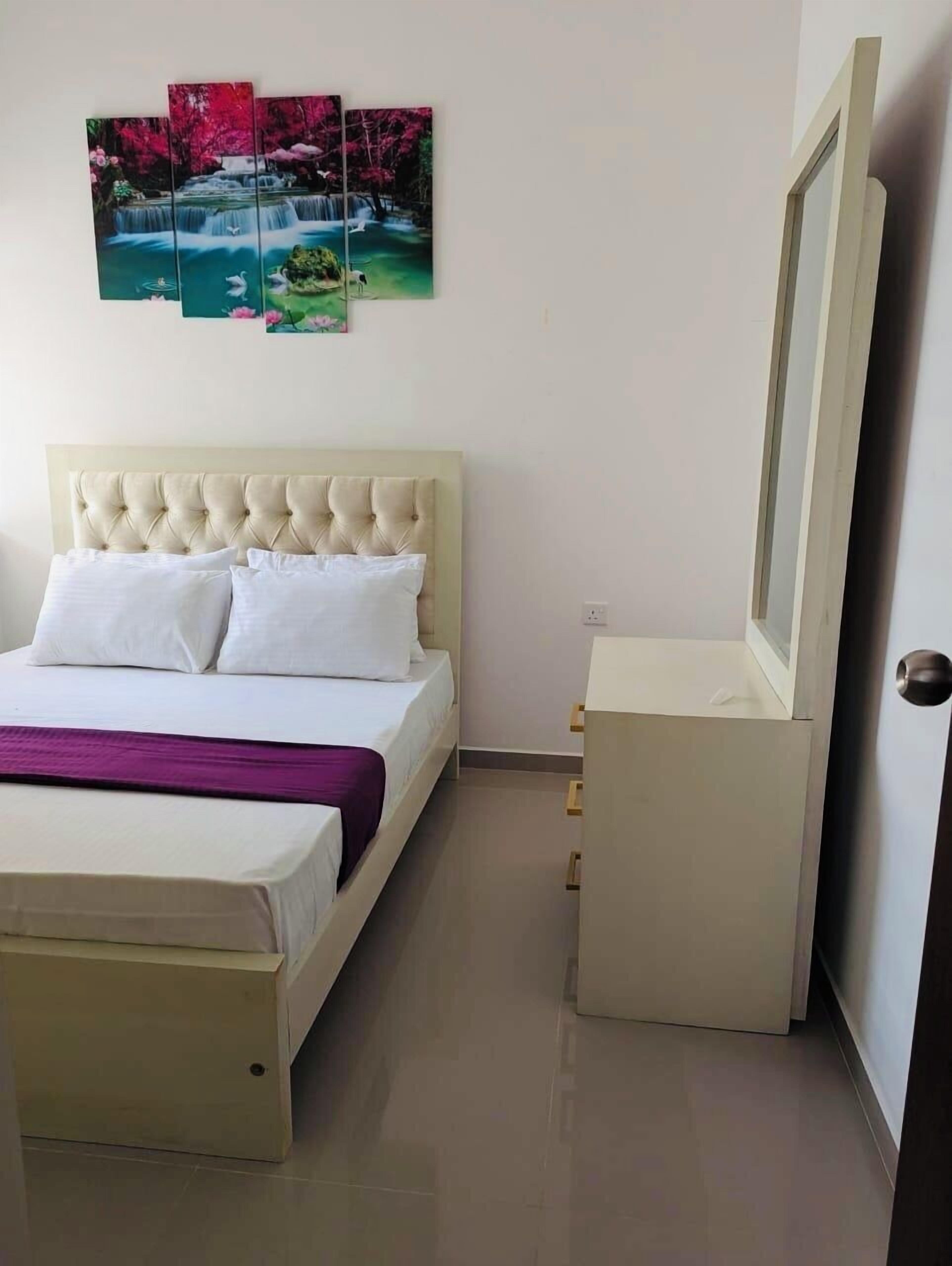 Un dormitorio con cama, cómoda, espejo y una obra de arte en la pared.