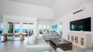 A spacious living room with a large TV, a wooden coffee table, and a sofa. - Pink Sands Point Main House 4 Bedroom Home (Governor's Harbour)