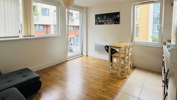 A modern apartment with a dining area, a sofa, and a kitchen. - Bright 1 bedroom flat, balcony, 8 min to London Bridge (London)