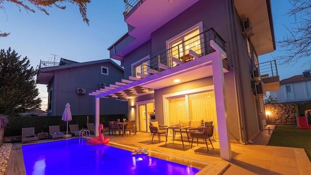 A modern house with a swimming pool, outdoor seating, and a covered patio area. - Close to Oludeniz 5 Bedroom Villa (Fethiye)
