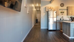A modern kitchen with a stainless steel refrigerator, wooden cabinets, and a built-in island with a sink.