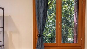 A room with two orange chairs, a small round table, and a window with curtains.