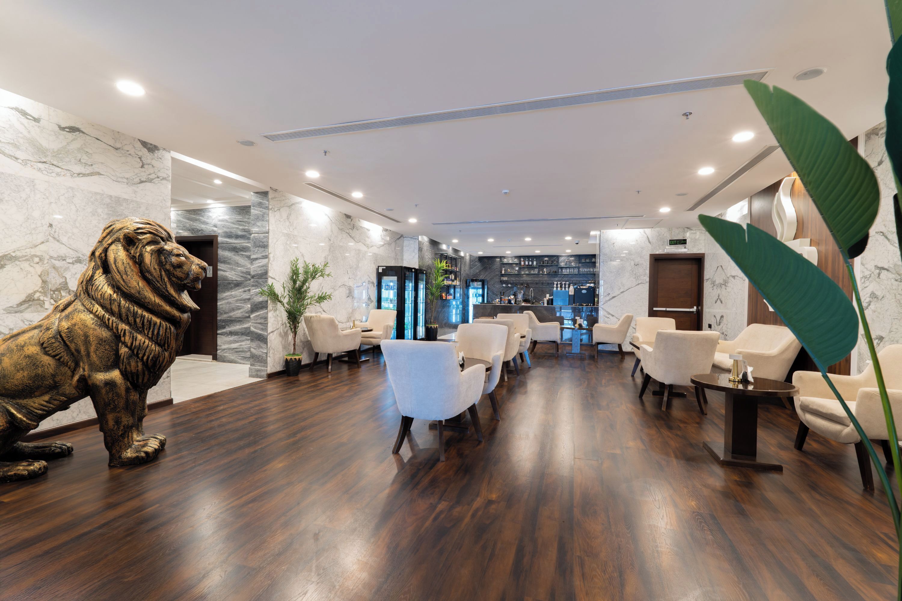 A lobby with marble walls, a lion statue, and modern furniture.