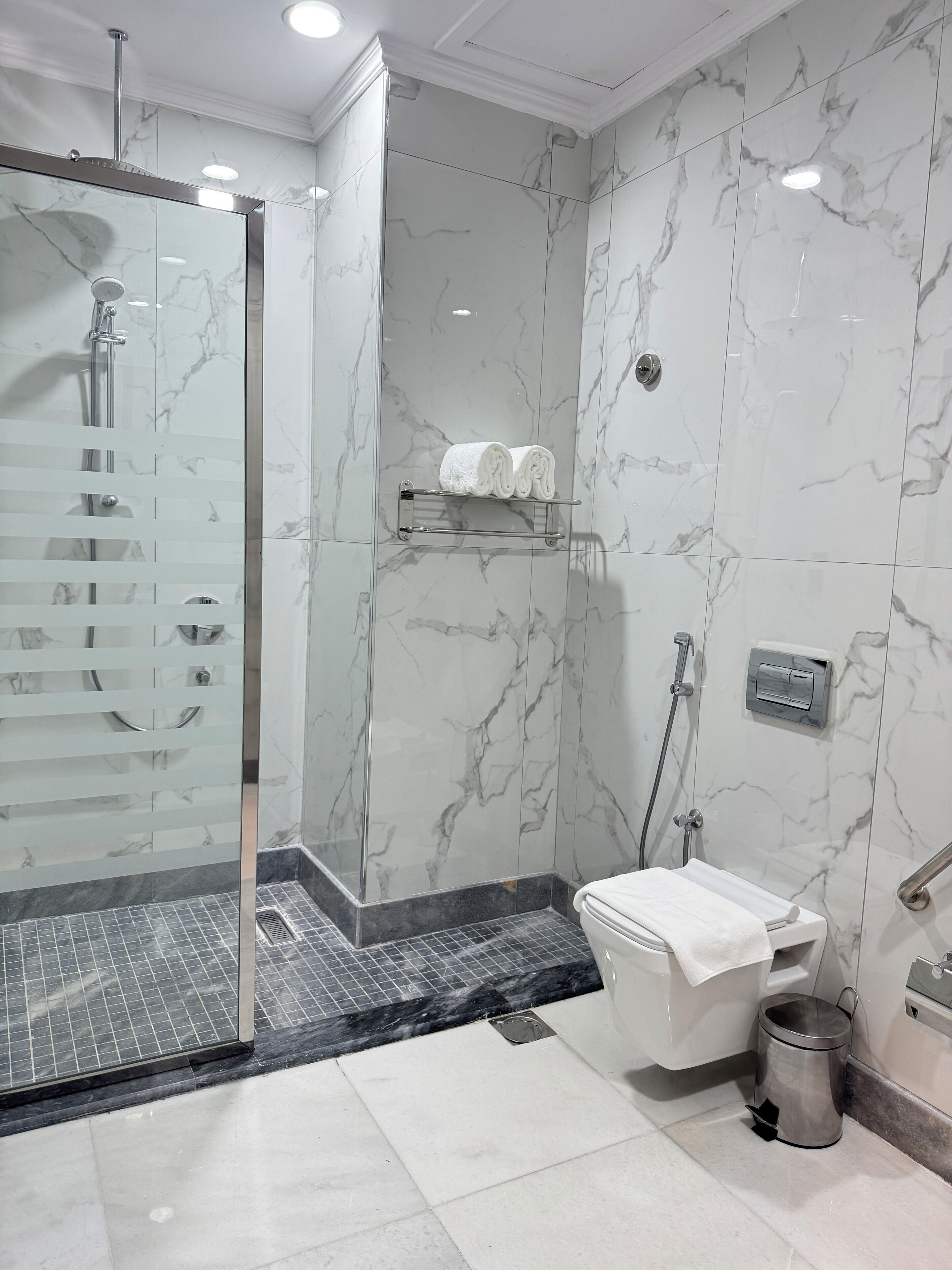 Un baño moderno con ducha envuelta en vidrio, inodoro y lavamanos.