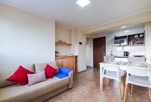 Cozy living space with a sofa, dining area, and fully equipped kitchen.