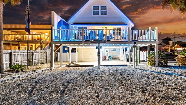A two-story house with a balcony, a garage, and a covered outdoor area.