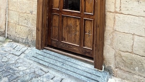 A wooden door with intricate carvings and a sign above it that reads "Diib House Hotel".