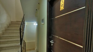 A staircase leading to a dark wooden door with a sign above it. - Tut & Pyramids View (Giza)