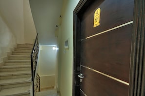 A staircase leading to a dark wooden door with a sign above it. - Tut & Pyramids View (Giza)