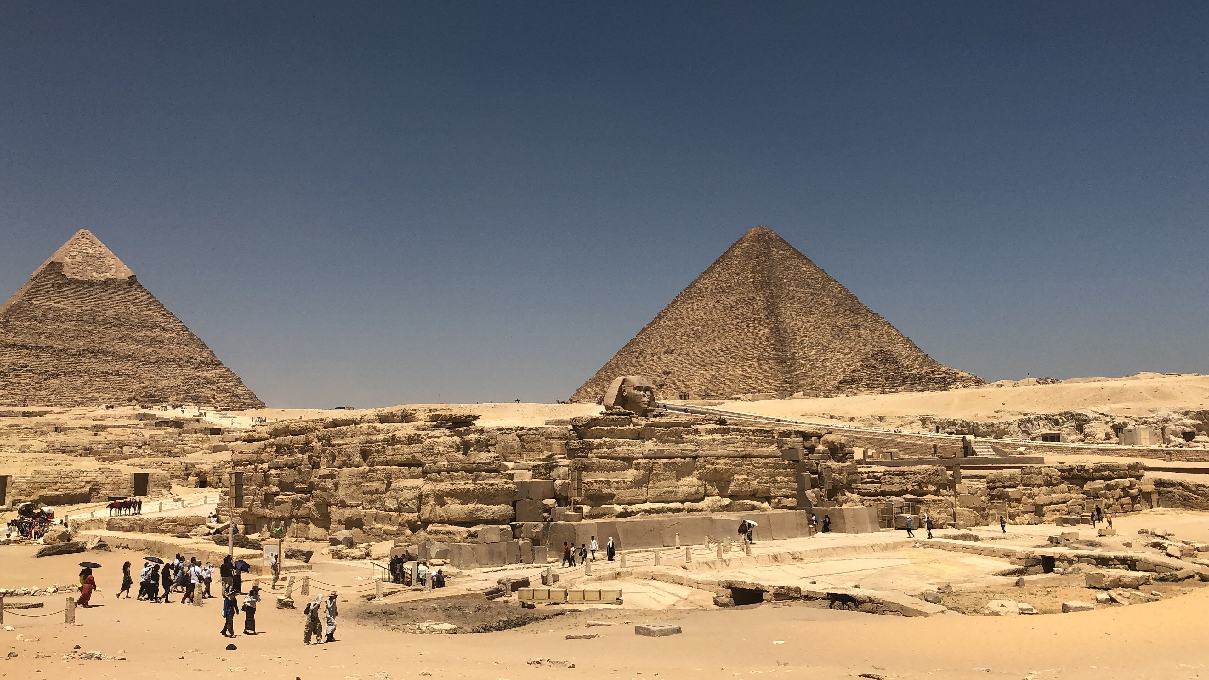 The Great Pyramids of Giza with visitors walking around the site.