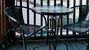 A balcony with two chairs and a table, overlooking a mountain and a town. - Mountain View Salzburg - SELF CHECK-IN - Apartments (Groedig)