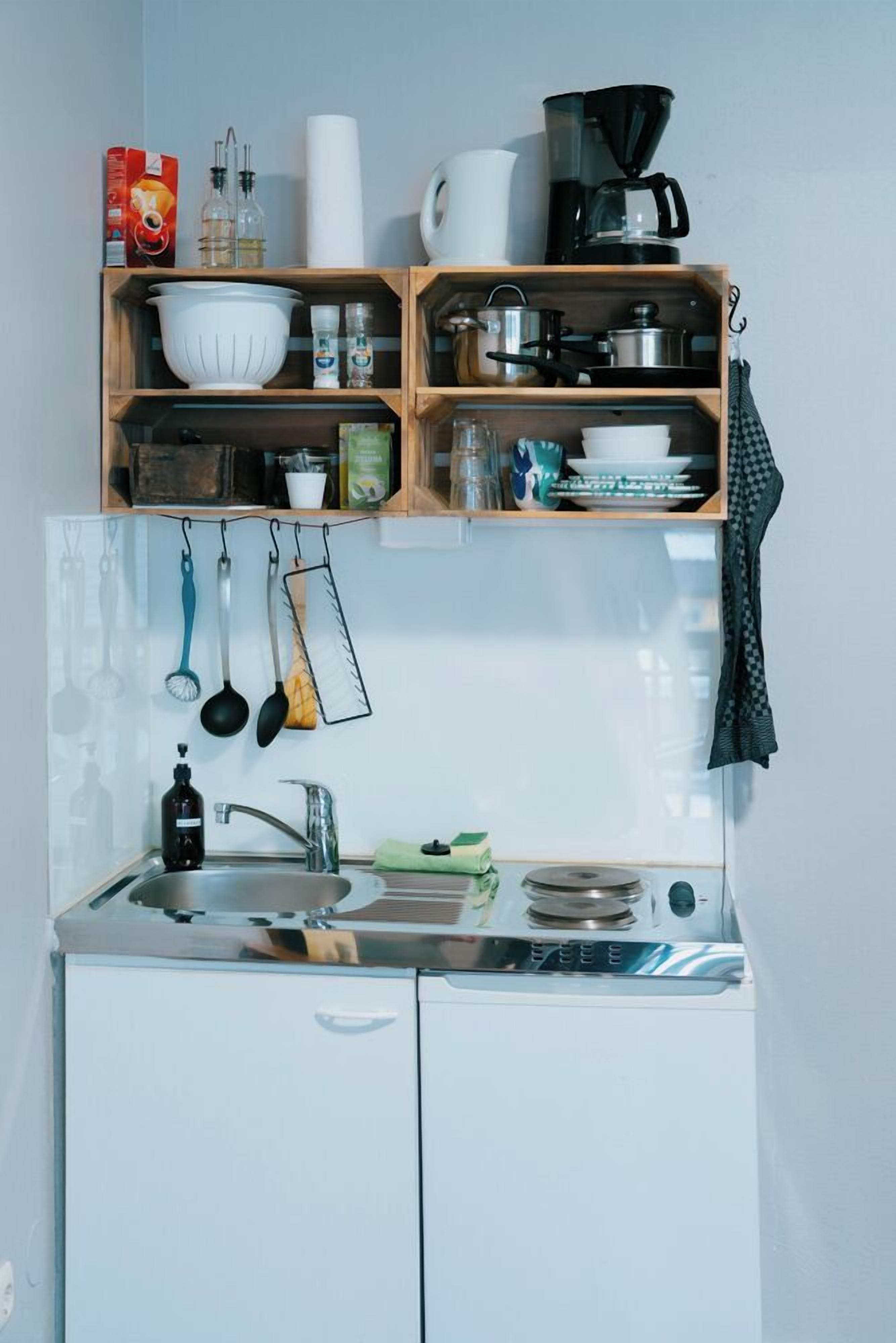A compact kitchen with a sink, stove, and various utensils.