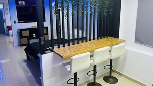 A modern bar area with a wooden counter and white bar stools.