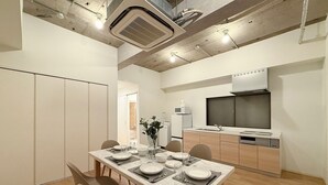 Une cuisine moderne équipée d’une cuisinière, d’un four à micro-ondes et d’un évier intégrés. On y trouve également un coin repas avec une table et des chaises en marbre.