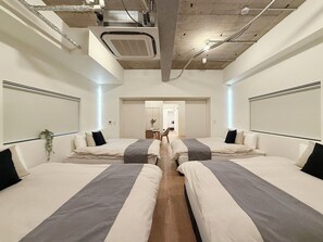 A hotel room with two beds, a ceiling fan, and a visible bathroom in the background. - Naou bld 301 (Hiroshima)