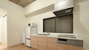 Une cuisine moderne équipée d’un lave-vaisselle encastré, d’un four à micro-ondes et d’une grande fenêtre au-dessus de l’évier.