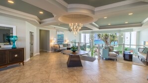 A spacious living area with a round table, a chandelier, and a view of the outdoors. - Stunning Views SBT 1006W (Destin)