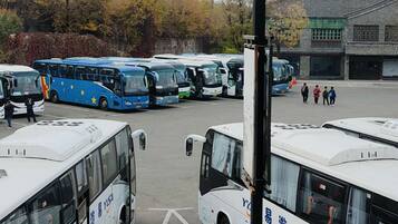 A parking lot with several buses parked.