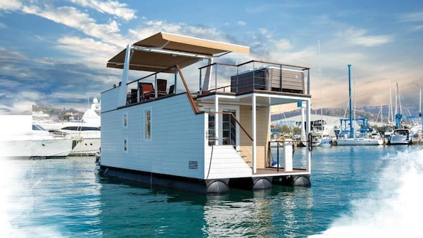 A floating houseboat with a covered deck, a small deck area, and a water entry ramp.