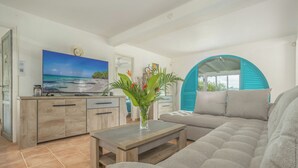 A modern living room with a sofa, coffee table, and a TV.