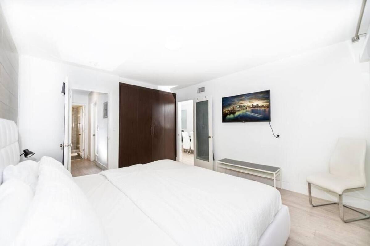 Une chambre d’hôtel avec un grand lit, un bureau, une chaise et un tableau au mur.