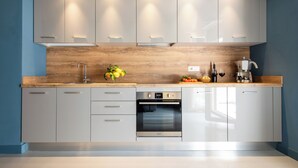 A modern kitchen with white cabinets, a wooden countertop, and built-in appliances including an oven and a coffee maker. - Comfortable apartment in Sorrento center (Sorrento)