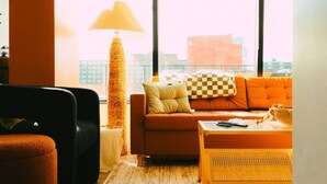 Ein modernes Wohnzimmer mit einer Couch, einem Hocker und einer Lampe.