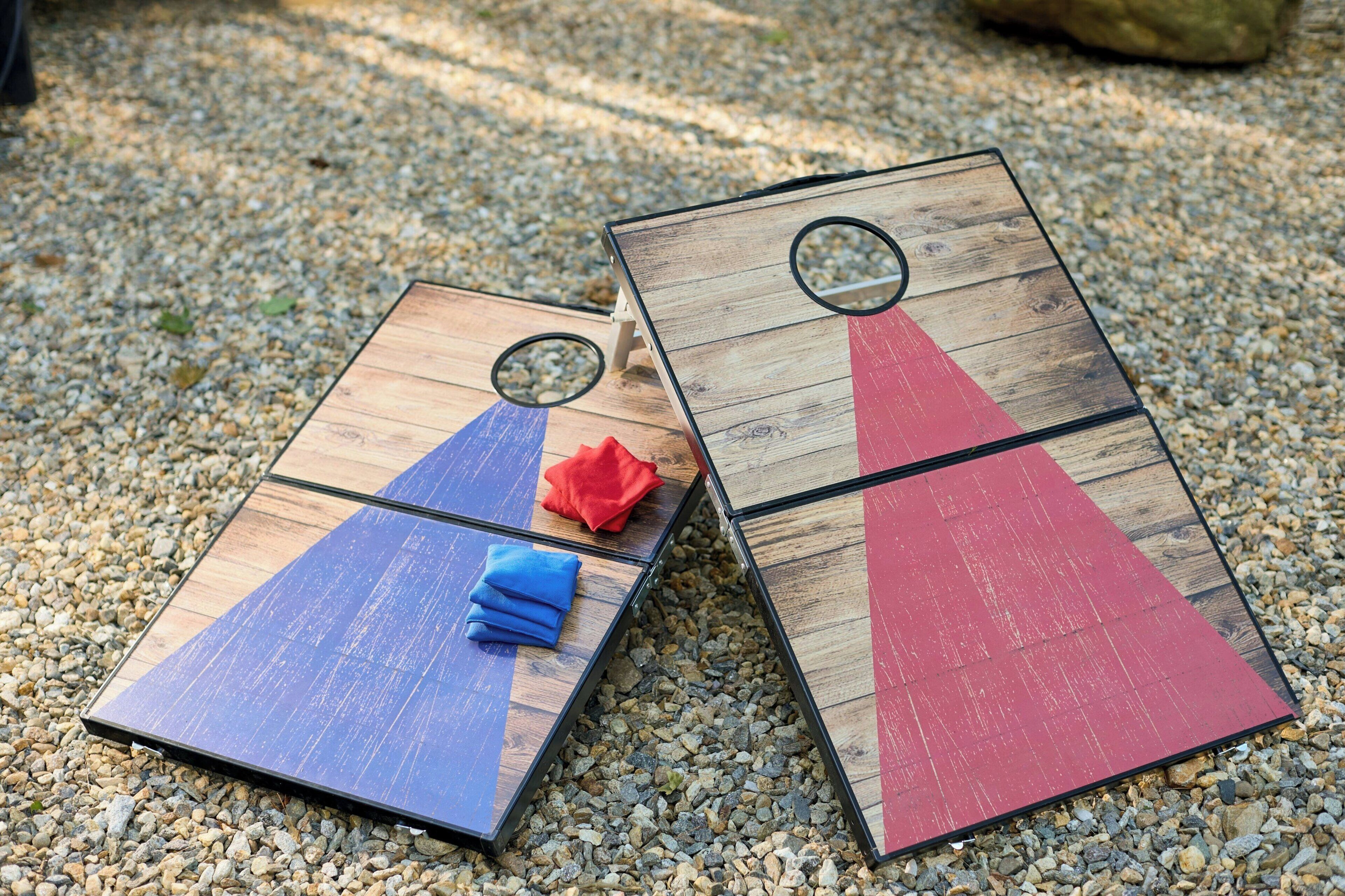 Two wooden boards with a circular hole, placed on a gravel surface.