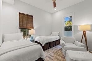 A bedroom with two beds, a chair, a lamp, and a window with a view of trees. - Close to Beach, 2 Kitchens, Private Pool, Hot Tub (Santa Rosa Beach)