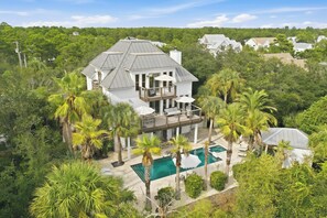 A large house with a pool, surrounded by palm trees and greenery. - Close to Beach, 2 Kitchens, Private Pool, Hot Tub (Santa Rosa Beach)
