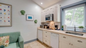 A compact kitchen with white cabinets, a microwave, a sink, and a window with blinds. - Yellowfin Ledge | Ideal Getaway On Duval! Balcony (Key West)