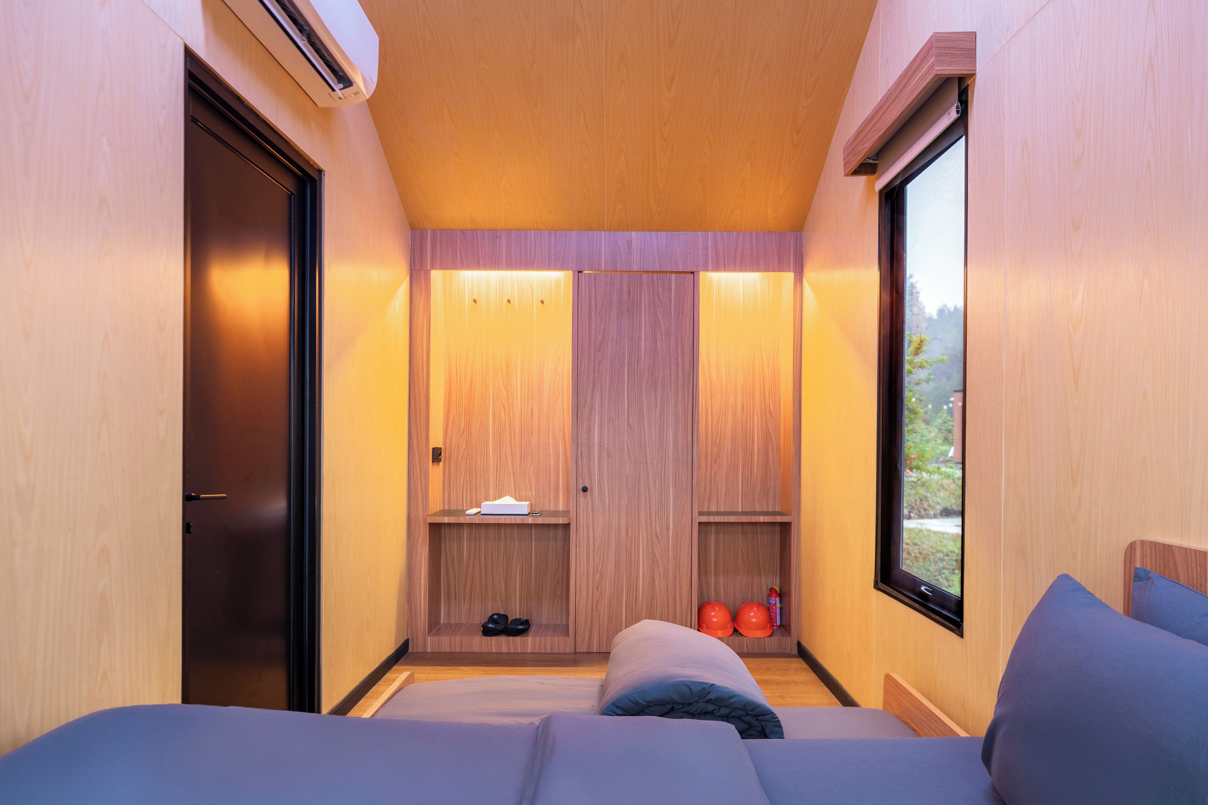 A compact bedroom with a bed, a wardrobe, a shelf with shoes, and a window.