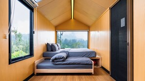 Een kleine slaapkamer met een bed, een raam en een deur.