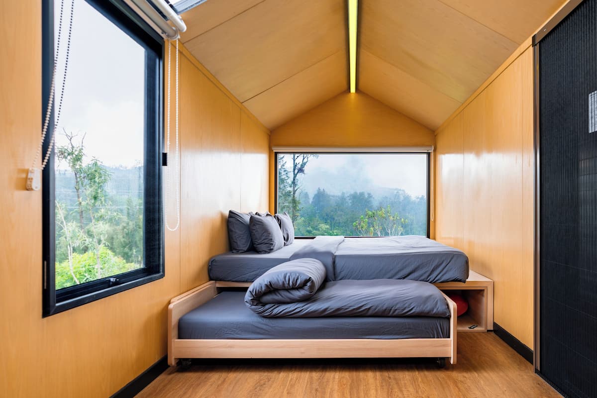 Une chambre à coucher de taille réduite, comprenant un lit, une fenêtre et une porte.