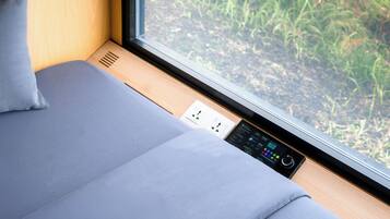 A modern room with a window, a power outlet, and a control panel.