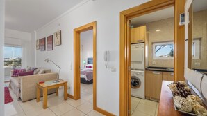 Eine moderne Wohnung mit Wohnzimmer, Essbereich, Küche und Waschraum.