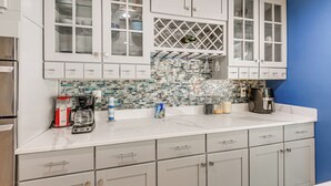 A modern kitchen with white cabinets, a tiled backsplash, and a coffee maker on the counter. - Pets Welcome: Quiet Silver Spring Retreat! (Silver Spring)