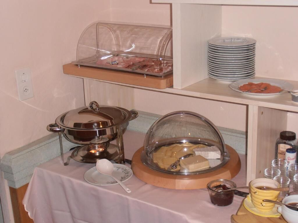 A buffet setup with various food items and serving utensils.