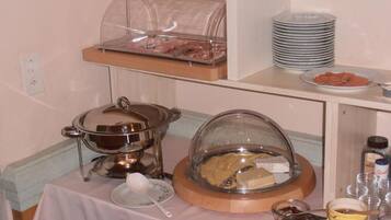 A buffet setup with various food items and serving utensils.