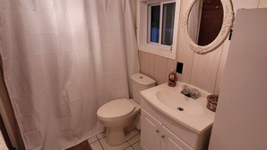 Un baño con inodoro, lavamanos y espejo.