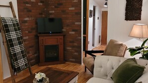 A living room with a fireplace, a television, a couch, and a coffee table.
