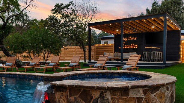 A pool with a hot tub, lounge chairs, and a covered seating area with string lights. - La Mariposa ~ Grand Oasis Big Luxury Home (Sunset Valley Austin)