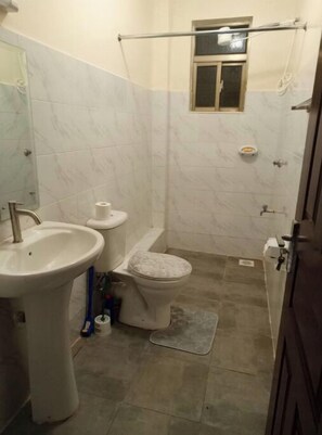 Een haardroger, handdoeken, zeep, toiletpapier