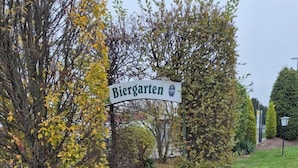 Een geplaveid pad dat leidt naar een bord met daarop 'Biergarten'.