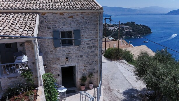 Un edificio de piedra con un balcón que da a la costa.