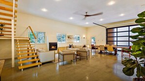A spacious living area with a fireplace, a staircase, and a dining area. - Gorgeous Lakeside BarnHOUSE + SAUNA! (Ashland)